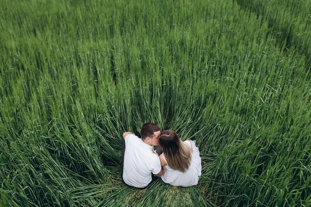 Photo gratuite le charmant couple amoureux assis sur le terrain