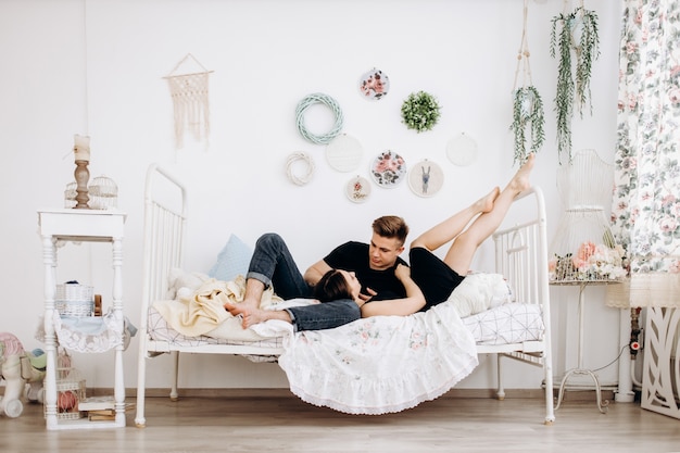 Le charmant couple amoureux embarqué et couché sur le lit