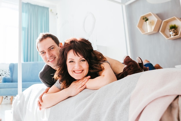 Le charmant couple amoureux se trouve sur le lit