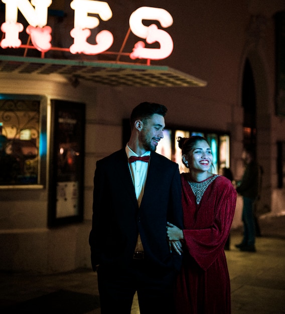 Charmante belle dame souriante marchant avec jeune homme dans la rue la nuit