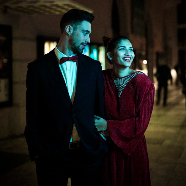 Charmante belle femme souriante marchant avec jeune homme dans la rue