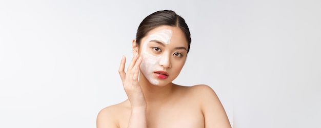 Charmante femme agréable, appliquer la crème sur la moitié du visage