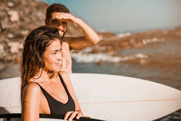 Photo gratuite charmante femme avec planche de surf près de petit ami