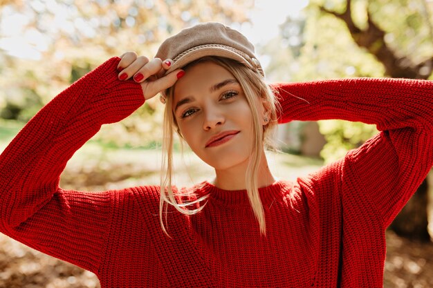 Charmante fille au joli chapeau léger et pull rouge