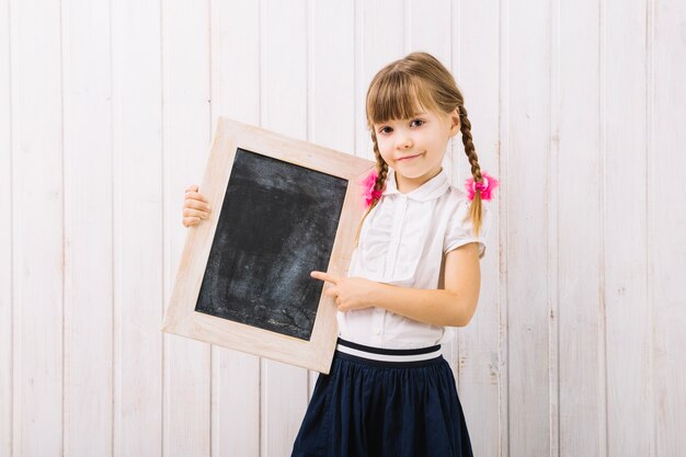 Charmante fille pointant au tableau