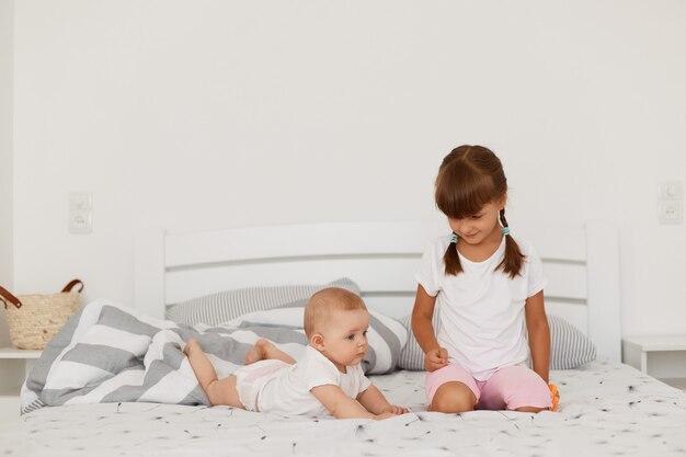 Bebe Nouveau Ne Fille Ou Garcon Couche Sur Une Couverture Sur Le Lit En Detournant Les Yeux Portant Un Body Blanc Et Des Chaussettes Un Bebe Etudiant Le Monde A Une Expression Endormie