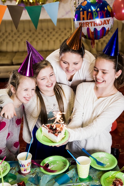 Charmantes filles avec un gâteau avec sparkler