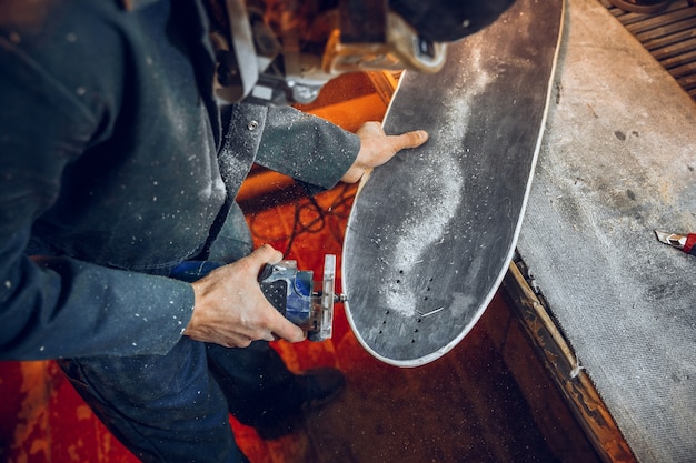 Charpentier à l'aide d'une scie circulaire pour couper des planches en bois