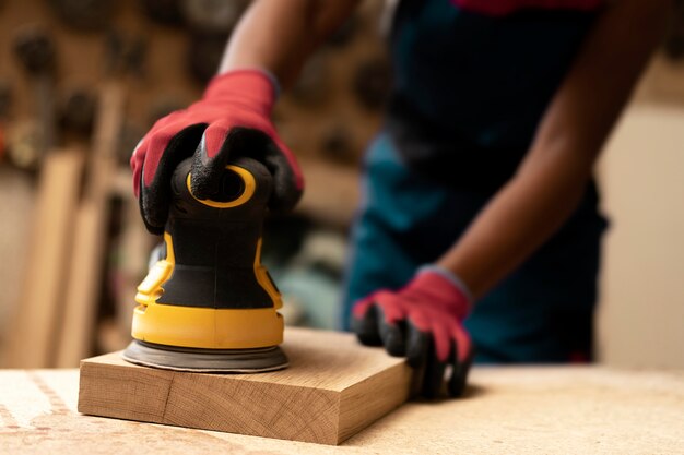 Charpentier coupant le panneau de forces de défense principale à l'intérieur de l'atelier