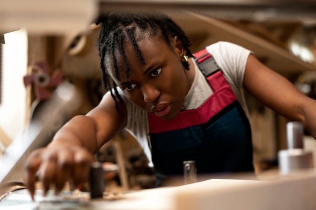 Charpentier coupant le panneau de forces de défense principale à l'intérieur de l'atelier