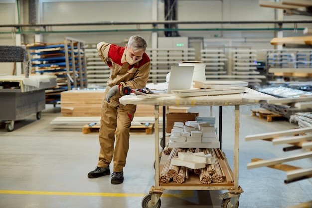 Charpentier épuisé ayant un mal de dos tout en travaillant dans un atelier