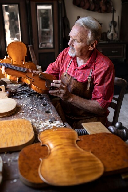 Charpentier principal contrôle instrument de violon qu'il est sur le point de réparer