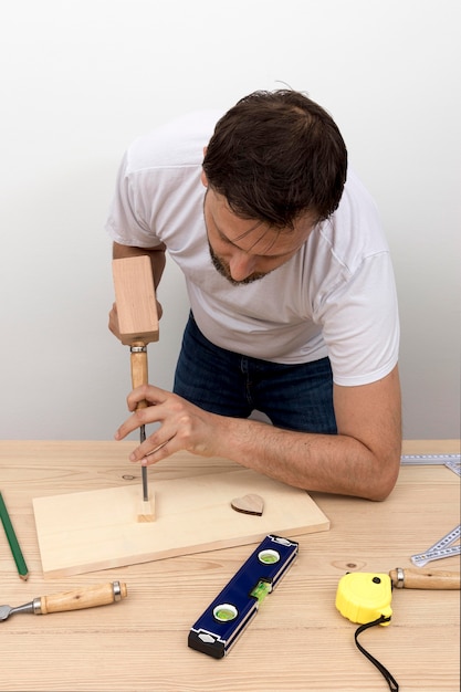 Photo gratuite charpentier qualifié à l'aide d'outils sur bois