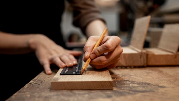 Une charpentière travaillant au studio avec un crayon.