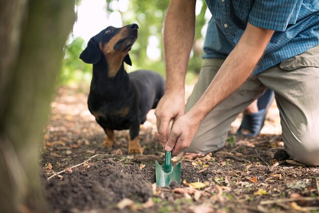 Chasseur de truffes et son chien dressé à la recherche de champignons truffiers dans la forêt