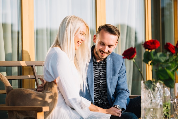 Photo gratuite chat debout près du couple assis dans le restaurant