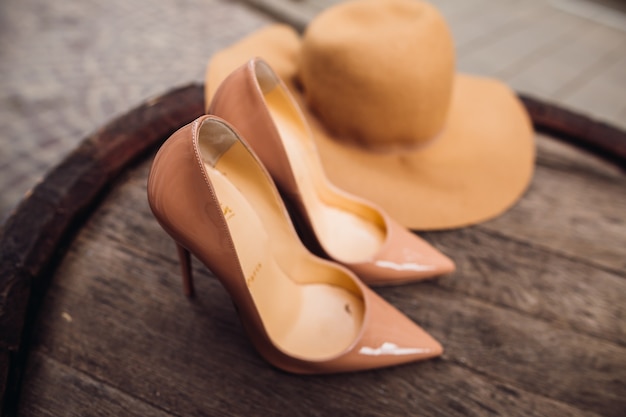 Les chaussures et le chapeau beige Luis Vuitton reposent sur le canon