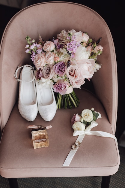 Chaussures de mariage, bouquet de mariage composé de fleurs roses et violettes sur la chaise