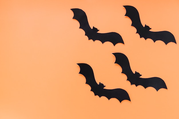 Chauves-souris en papier noir sur fond orange