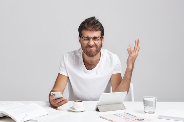 Échec, dépression nerveuse et stress au travail. Jeune gestionnaire européen en colère stressant avec barbe grimaçant et gesticulant