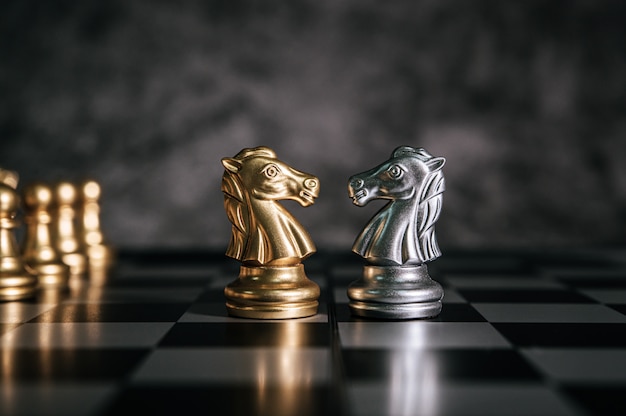 Échecs d’or et d’argent sur le jeu d’échecs pour le concept de leadership métaphore de l’entreprise