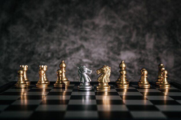 Échecs d’or et d’argent sur le jeu d’échecs pour le concept de leadership métaphore de l’entreprise