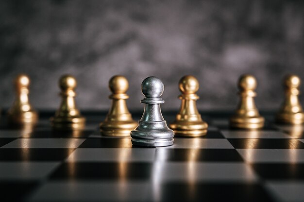 Échecs d’or et d’argent sur le jeu d’échecs pour le concept de leadership métaphore de l’entreprise