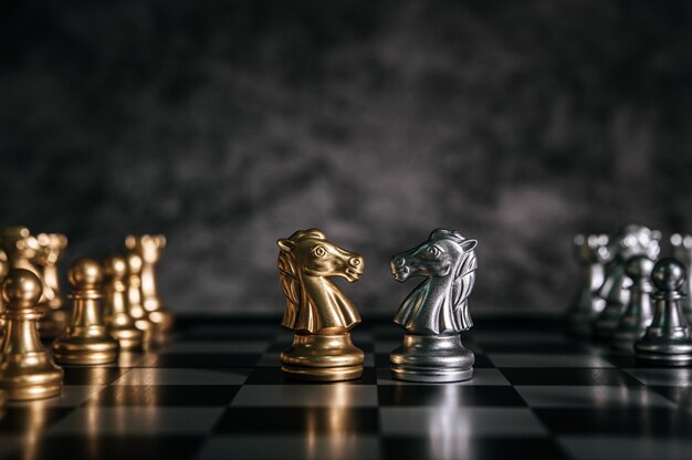 Échecs d’or et d’argent sur le jeu d’échecs pour le concept de leadership métaphore de l’entreprise