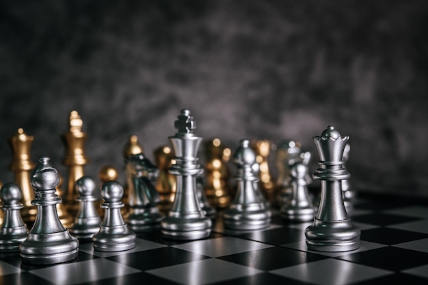 Échecs d’or et d’argent sur le jeu d’échecs pour le concept de leadership métaphore de l’entreprise