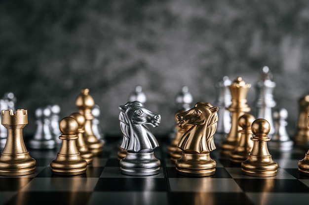 Échecs d’or et d’argent sur le jeu d’échecs pour le concept de leadership métaphore de l’entreprise