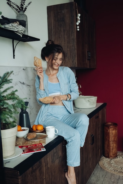 Cheerful brunette woman holding pâtisseries dans la cuisine