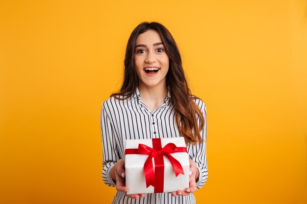 Cheerful brunette woman in shirt holding coffret cadeau