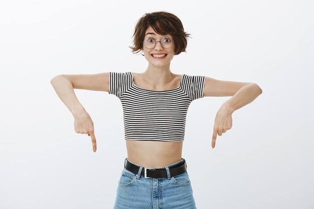 Cheerful Happy Woman Pointant Les Doigts Vers Le Bas Et Souriant Excité, Montrant La Bannière Publicitaire