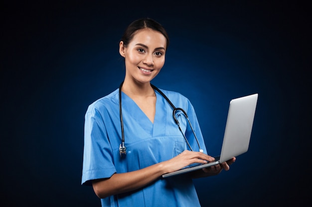 Cheerful Lady In Medical Uniform Using Laptop