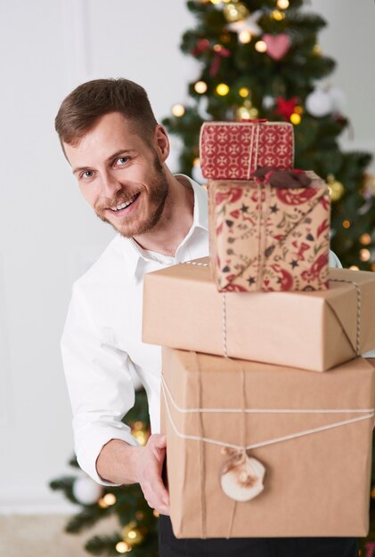 Cheerful man holding pile de cadeaux