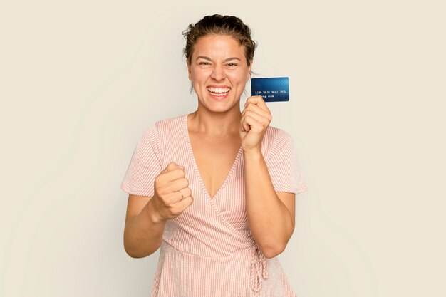 Cheerful shopaholic woman holding paiement sans numéraire par carte de crédit