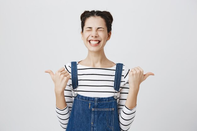 Cheerful woman se réjouissant en pointant sur le côté