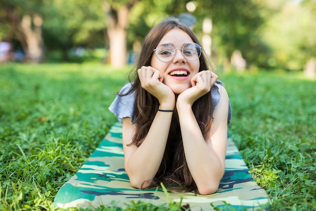 Cheerful woman wearing robe lumineuse couchée sur l'herbe