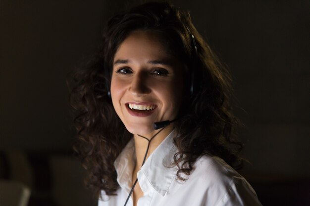 Cheerful young businesswoman in headset