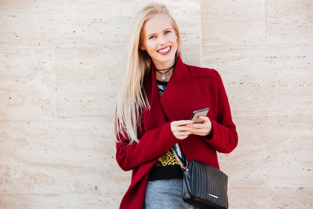 Cheerful young caucasian woman walking outdoors discuter