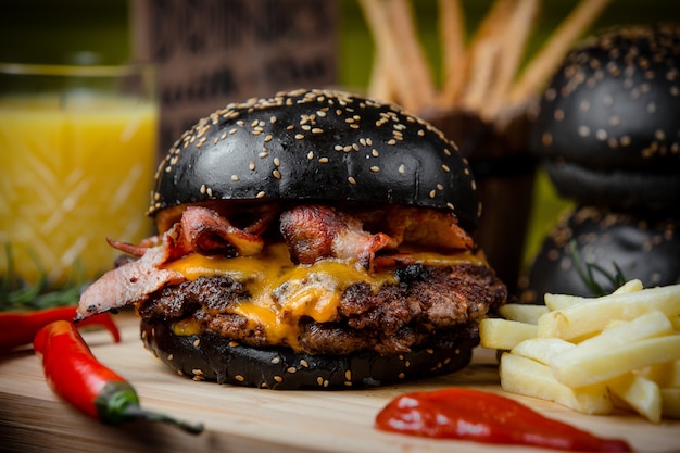 Cheeseburger à la viande avec bacon et frites pain brun