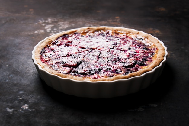 Cheesecake aux framboises sur une table en bois foncé