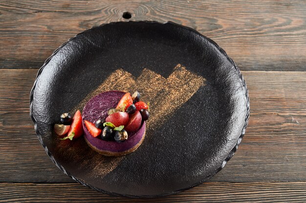 Cheesecake violet aux fruits rouges sur assiette