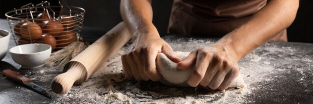 Chef à l'aide des mains et de la farine pour pétrir la pâte