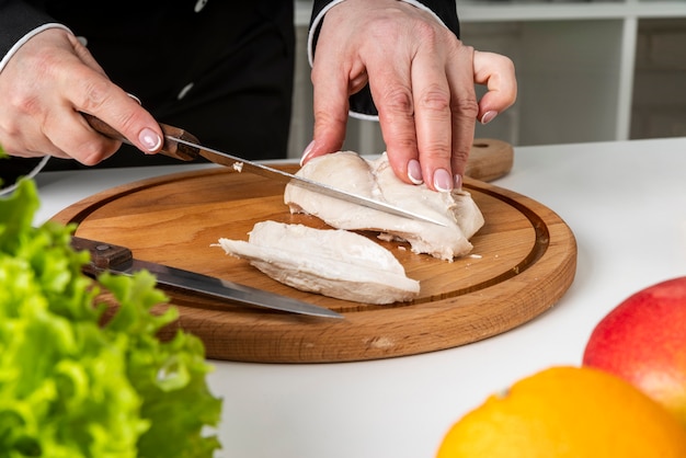 Chef à l'aide d'une planche à découper et d'un couteau