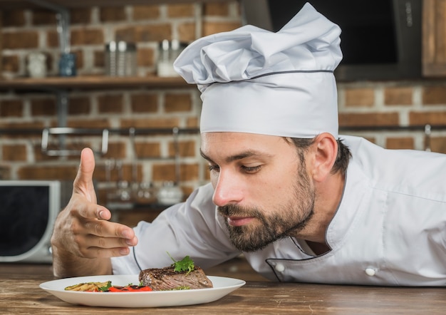 Photo gratuite chef appréciant l'arôme de la nourriture servie sur la plaque