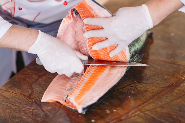 Le chef coupe le saumon sur la table
