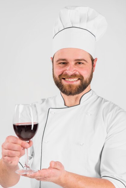 Chef cuisinier souriant et tenant un verre de vin