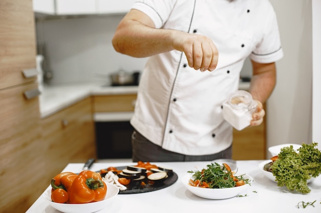 Chef debout dans la cuisine à la maison, cuisine