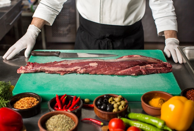 Chef debout dans la cuisine pour préparer le steak de bœuf